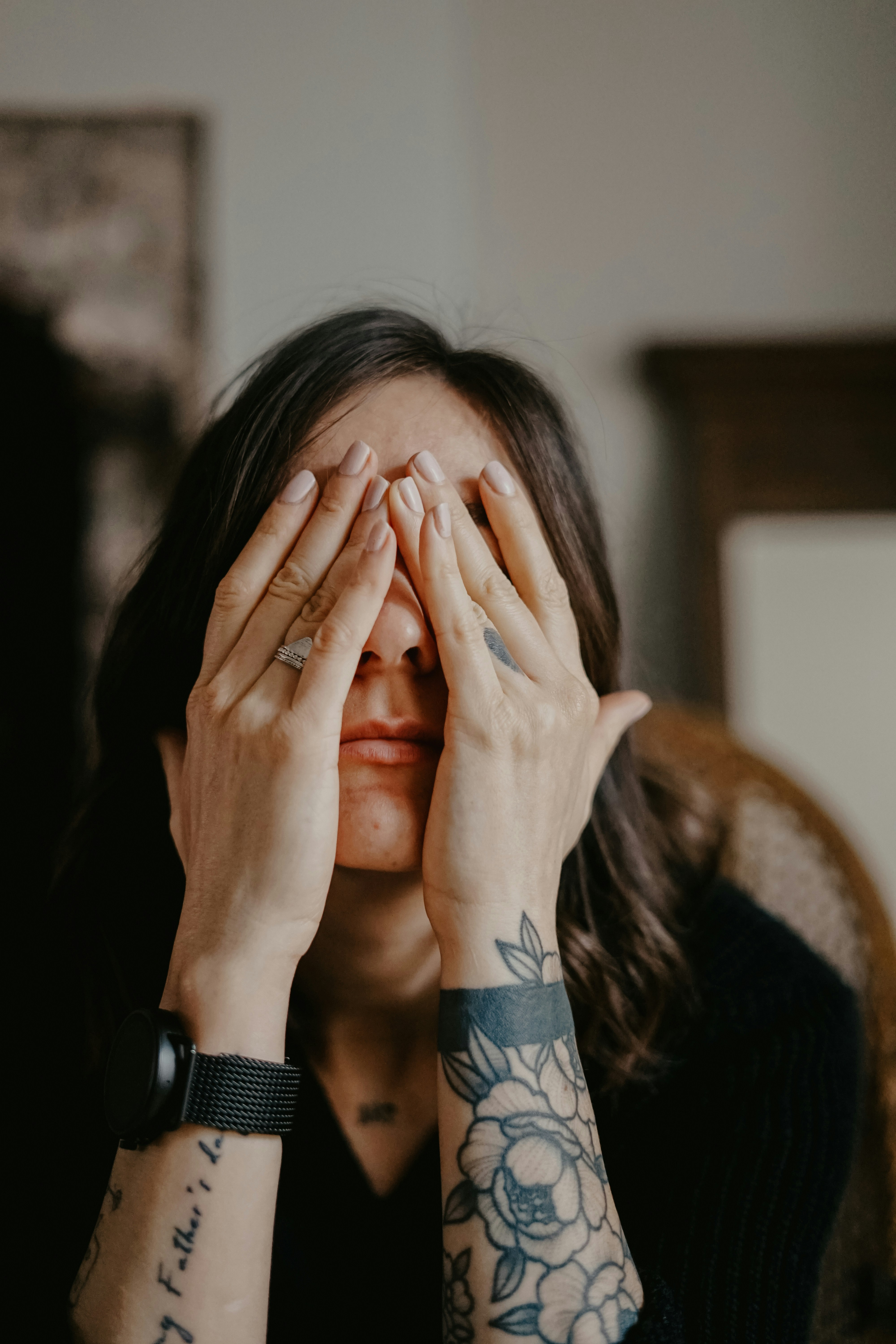 A woman in a black long sleeve shirt covering her face